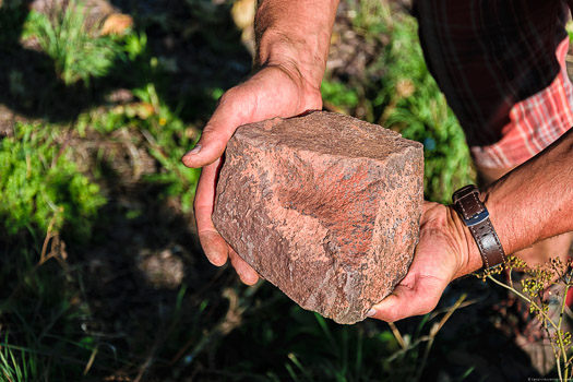 Das rote Gestein des Weinbergs an der Saar ist sehr eisenhaltig. Der Stein befindet sich in den Händen vom Winzer Cord Treseler.