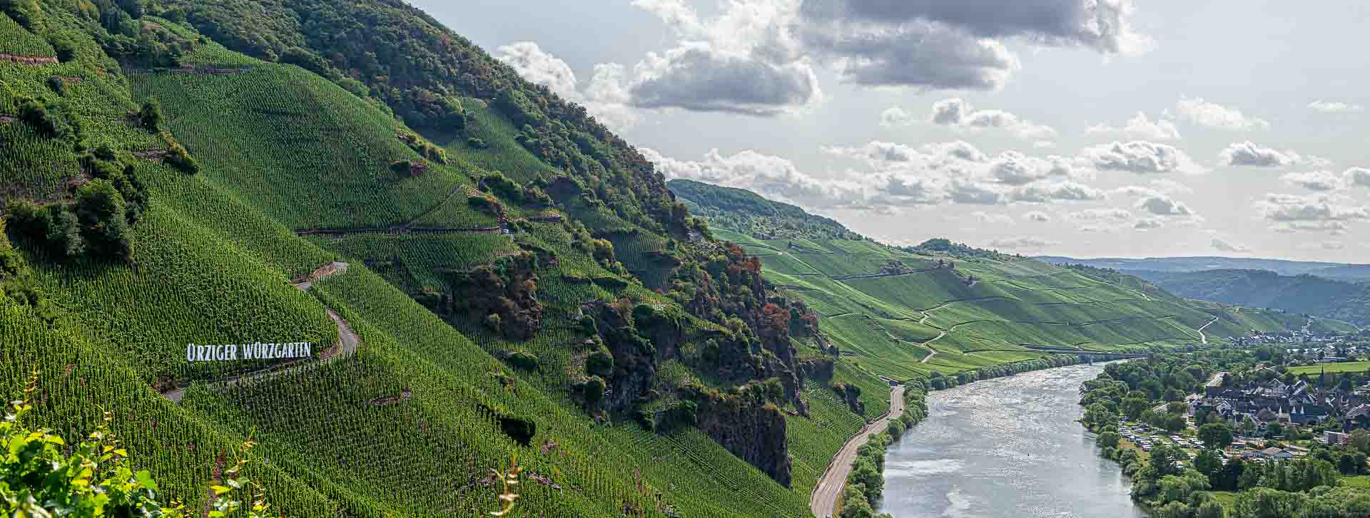 Eindrucksvoller Blick vom Ürziger Würzgarten auf den Weinberg Erdener Prälat, Wolken im Hintergrund, Mosel rechts unten