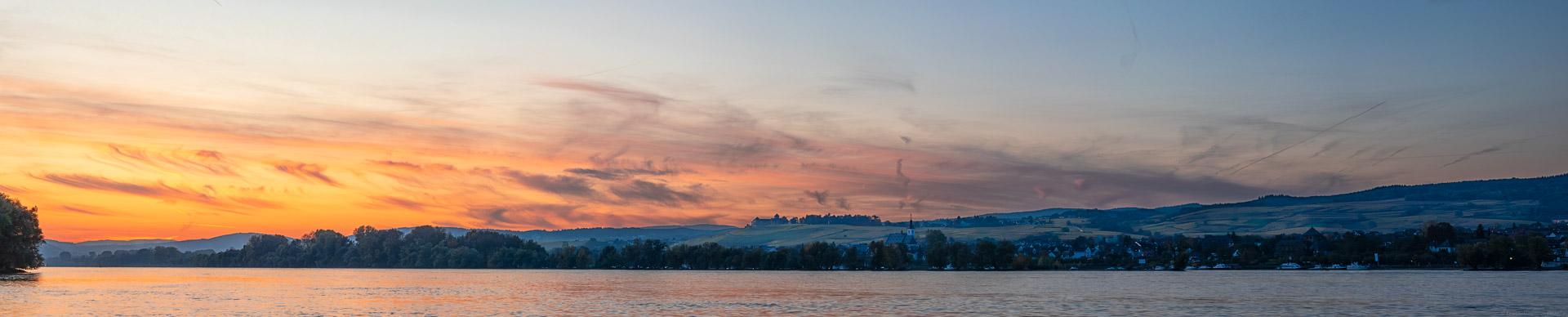 Blick über den Rhein auf einen feurigen Sonnenuntergang über dem Rheingau. Titelbild der Vinaet Kontakt Seite.