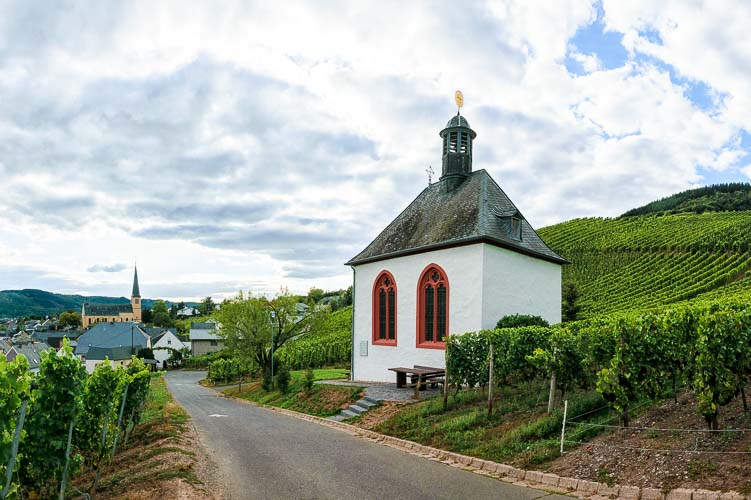 Kleine Kapelle im Weinberg Kröver Letterlay mit Ort Kröv im Hintergrund und bewölktem Himmel