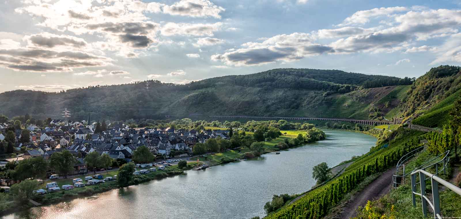 Der Ort Pünderich befindet sich innerhalb einer Biegung der Mosel. Am anderen Ufer liegt der Weinberg Pündericher Marienburg.