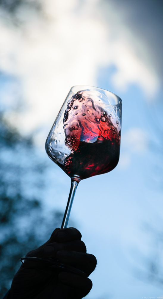Rotwein Glas mit Cabernet Sauvignon und mit blauem Himmel und Wolken