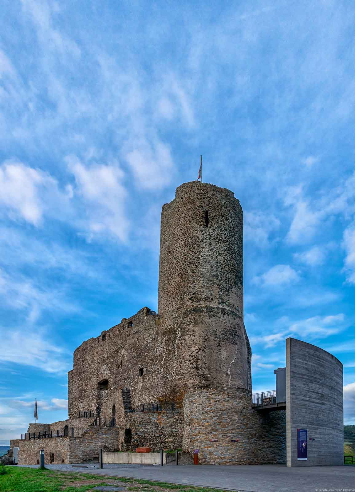 Oberhalb von Bernkastel-Kues liegt die Burgruine Grevenburg. Runde im die Grevenburg ist blauer Himmel mit einigen Wolken.