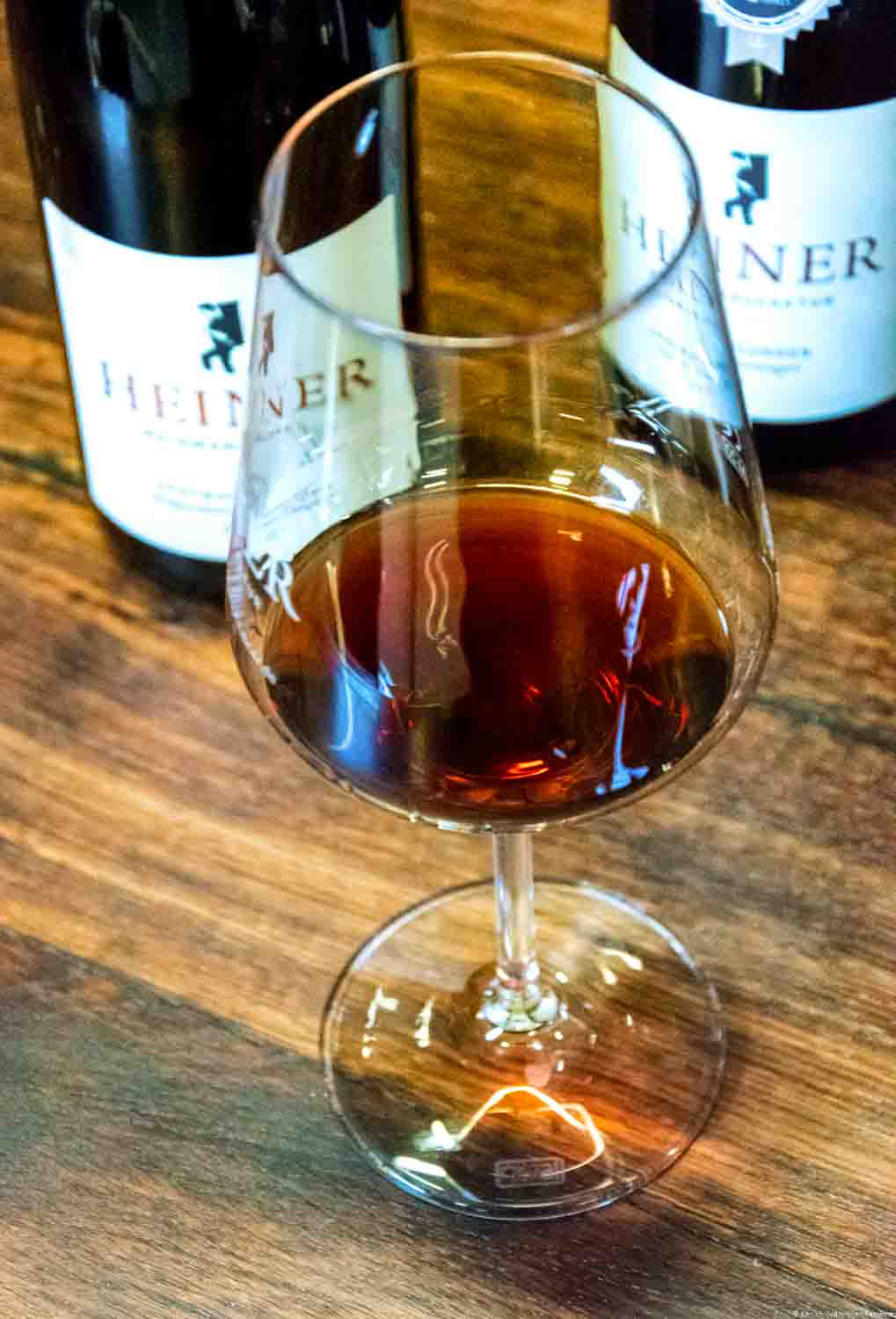 Glas mit Rotwein der Weinmanufakatur Heiner an der Ahr auf Holztisch