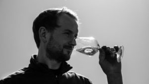 VinVenture Winzer Lukas Bicking mit Weinglas im Weinberg