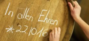 Weinfass mit dem Namen "In allen Ehren" wird beschriftet
